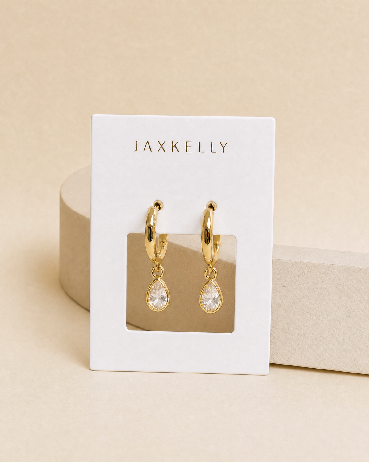 Gold hoop earrings with teardrop CZ charm dangle and clear white stone accents