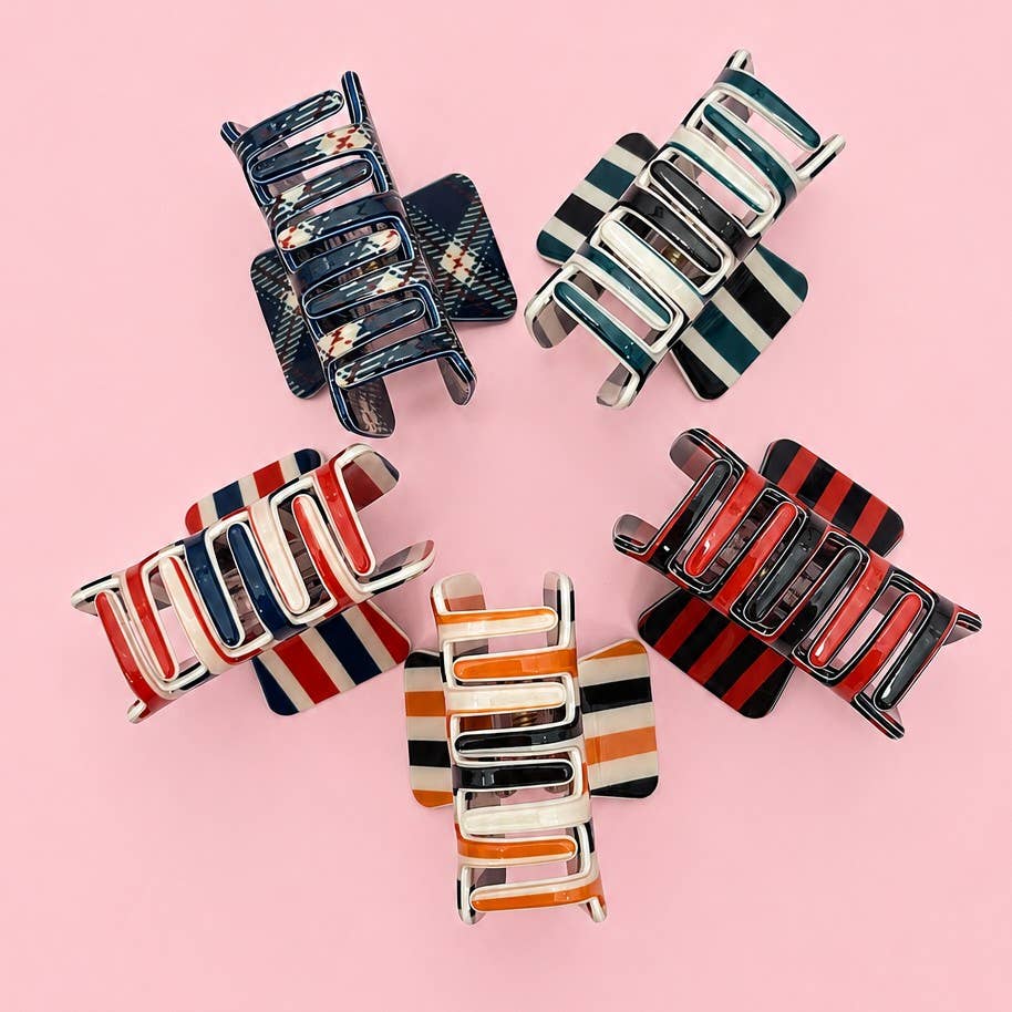 Assorted hair claw clips with striped and plaid patterns in navy, red, and orange