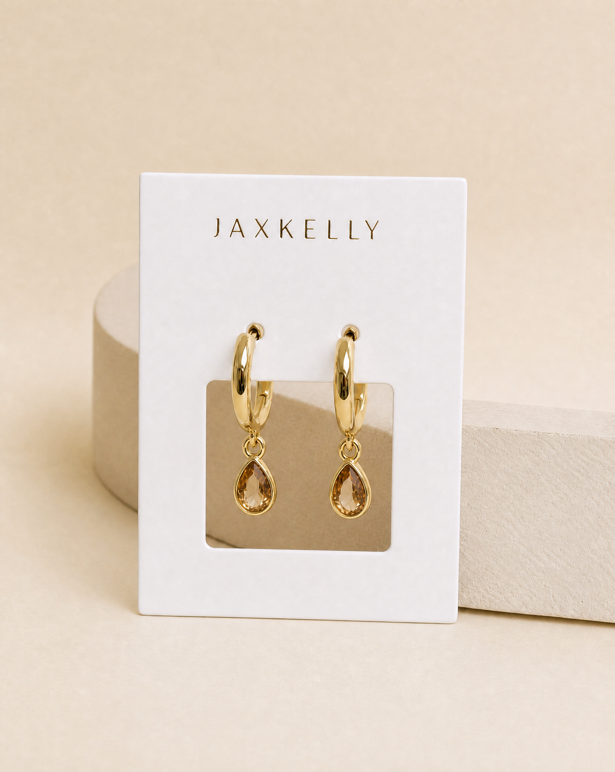 Gold teardrop charm hoop earrings with small CZ sparkle, dangling from hinged hoops