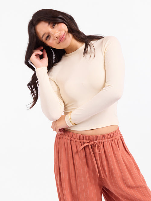 Cream fitted crewneck long-sleeve top, crew neckline with slight stretch drape