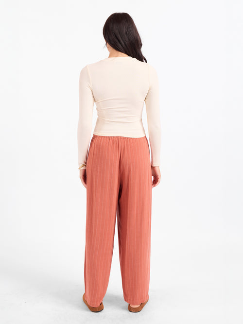 Cream crewneck top viewed from back, long sleeves and fitted waist length