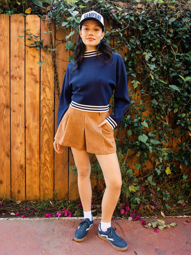 Tan faux suede shorts with front pleats and side pockets, button-and-zip closure