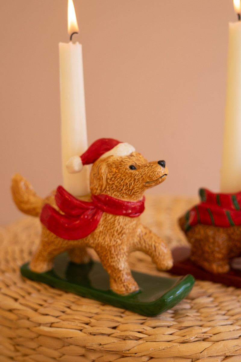 Close-up ceramic dog taper candle holder with red scarf and green candle base