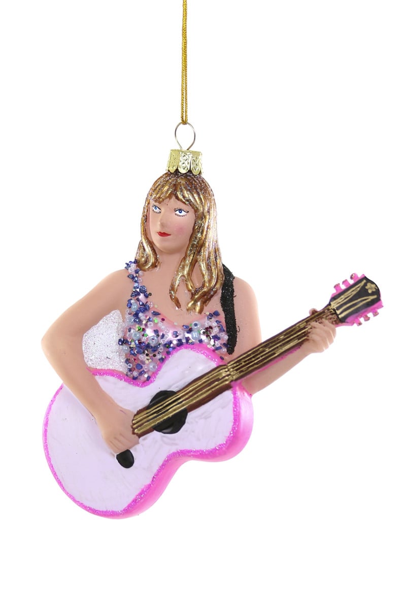 Taylor Swift guitar ornament: blonde figure holding pink and purple guitar, hanging on gold cord