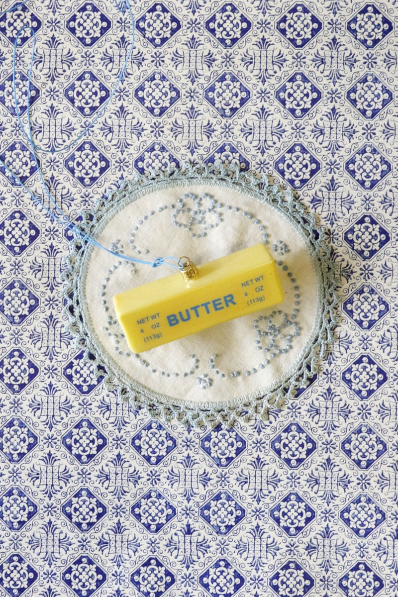 Small butter stick ornament hanging on string, placed on circular wreath