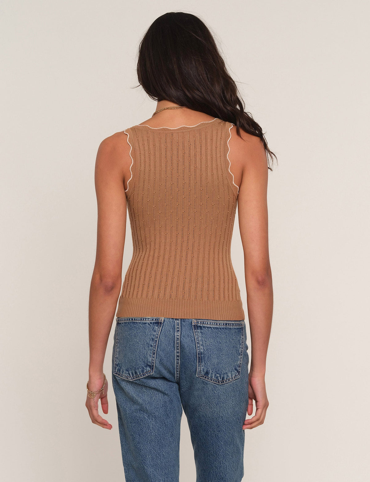 Back view of camel ribbed knit sleeveless top with scalloped neckline and fitted hem