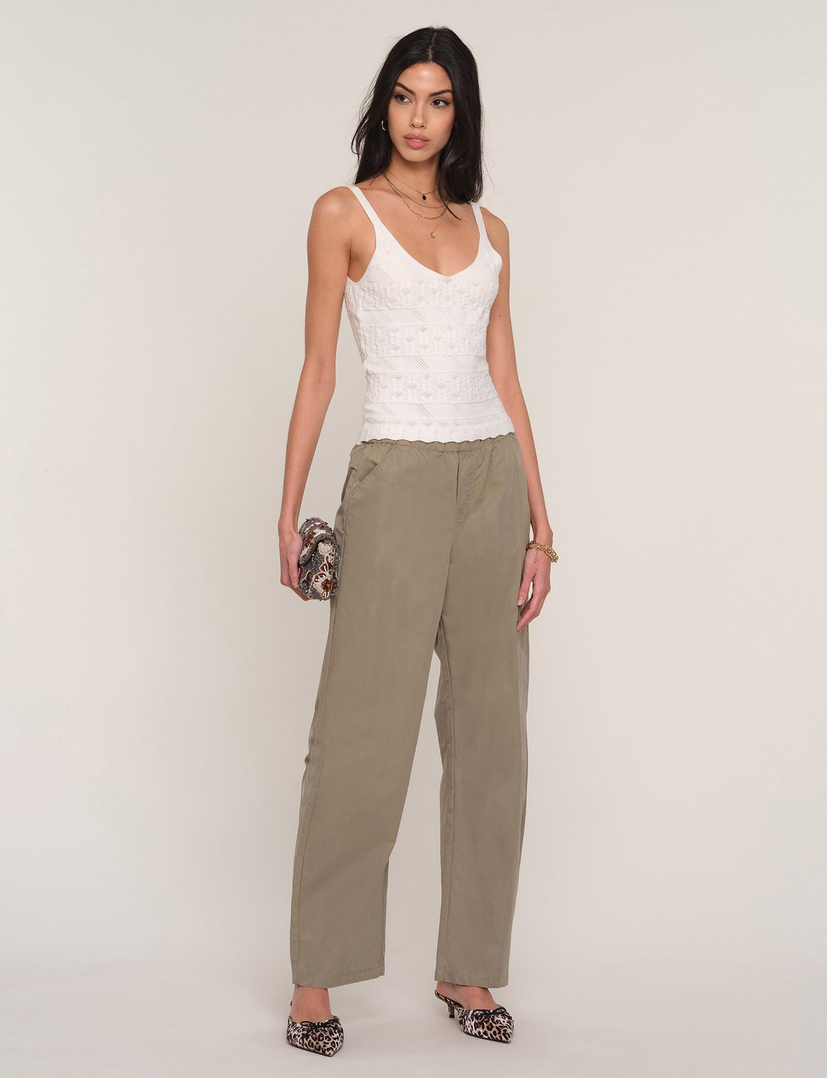 White cami with V-neck, thin straps, scalloped lace texture, ruffled hem