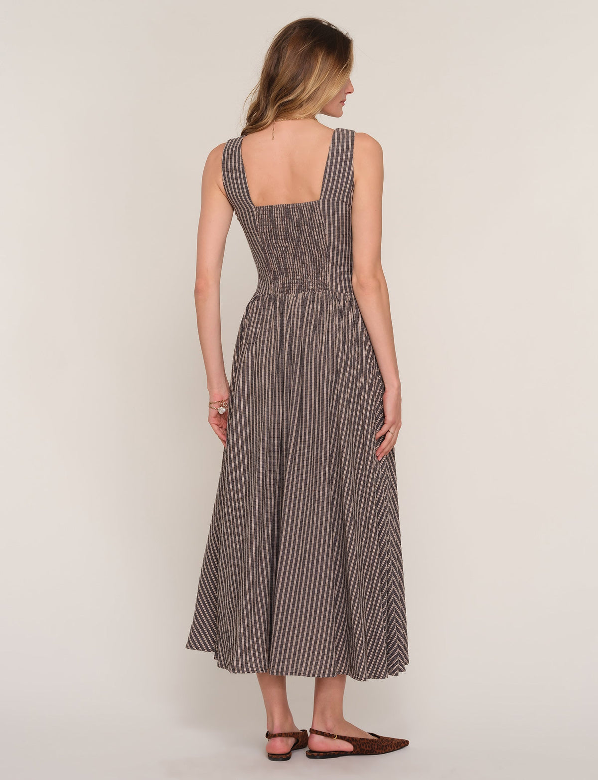 Back view of sleeveless midi dress with vertical stripe print and scoop back