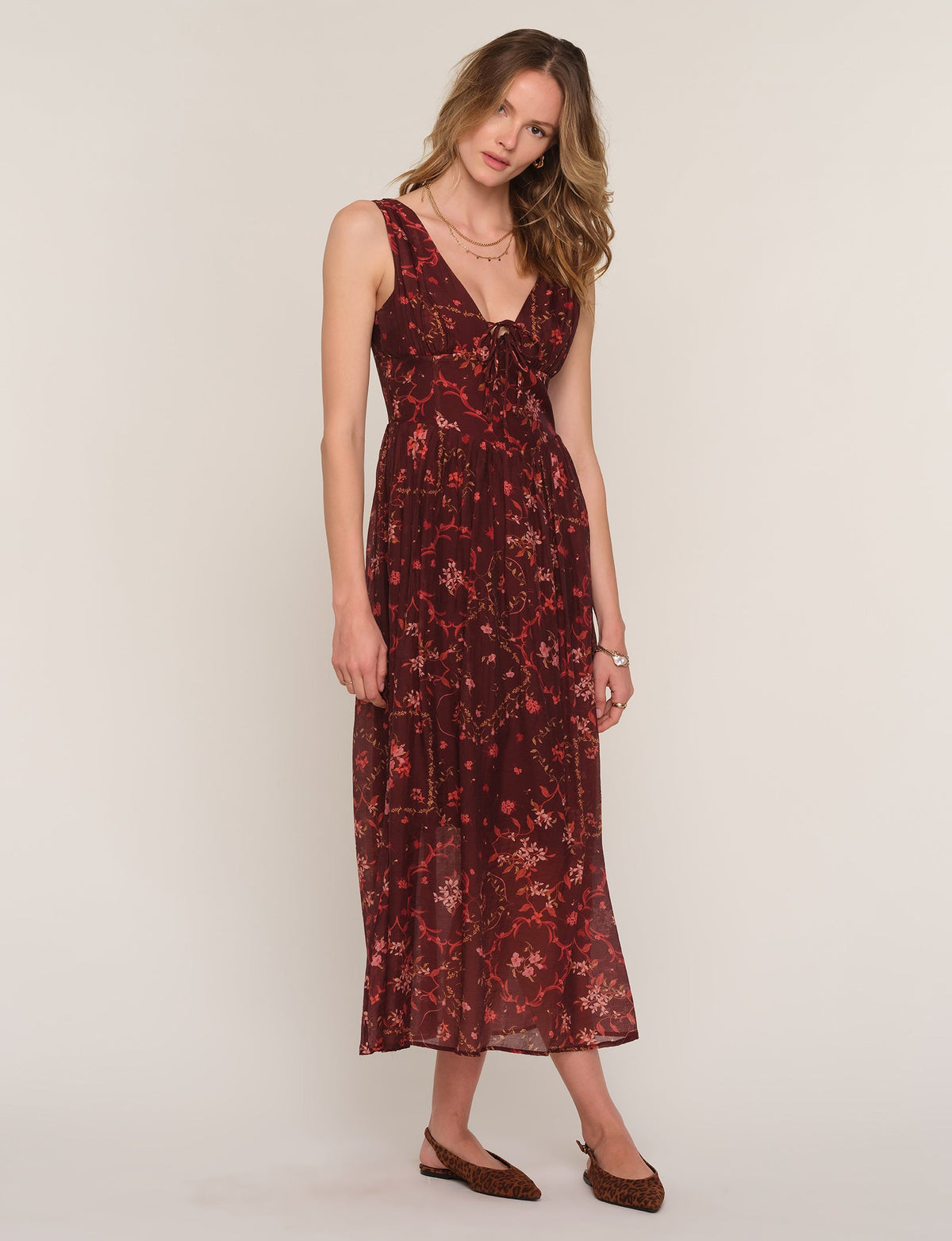 Sleeveless V-neck midi dress with dark burgundy floral pattern and flowing skirt