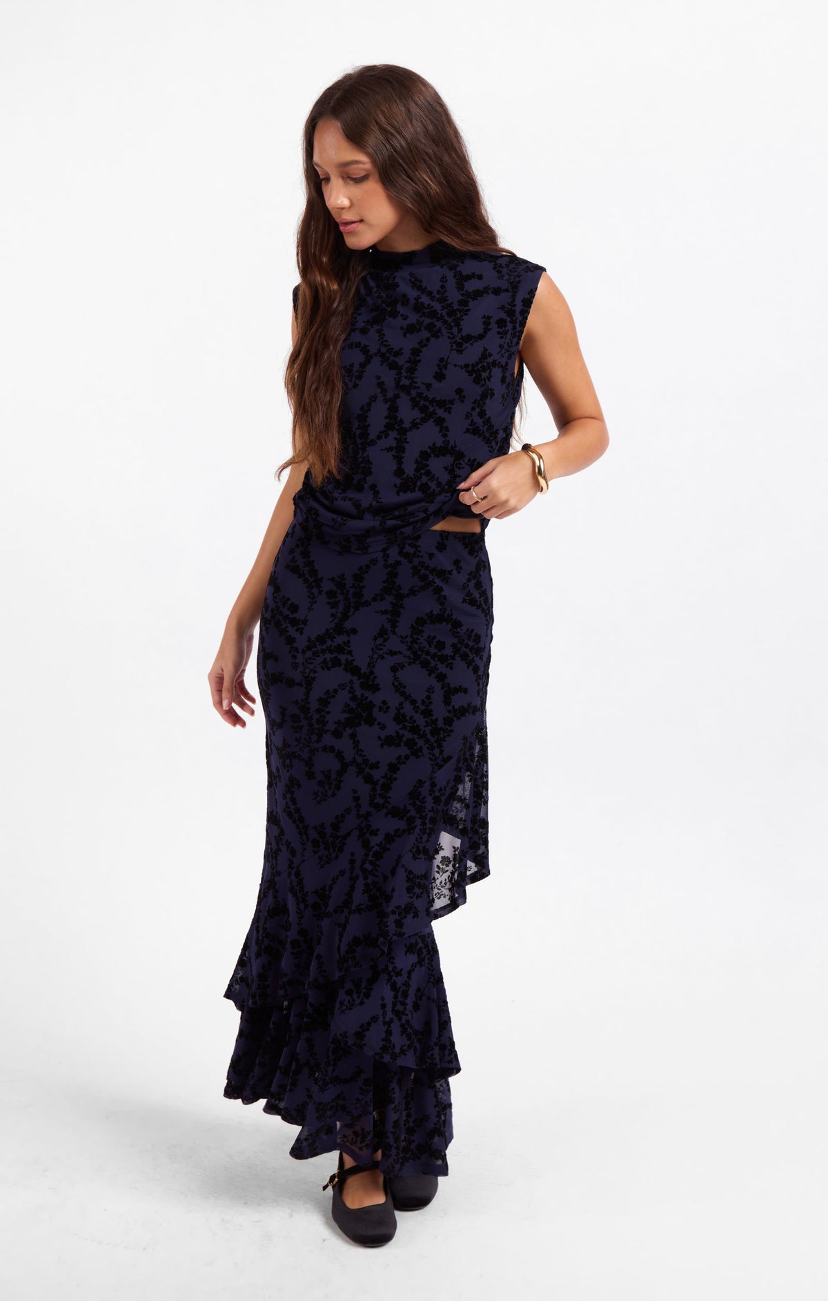 Dark navy sleeveless mesh top with high neck, fitted silhouette, layered hem