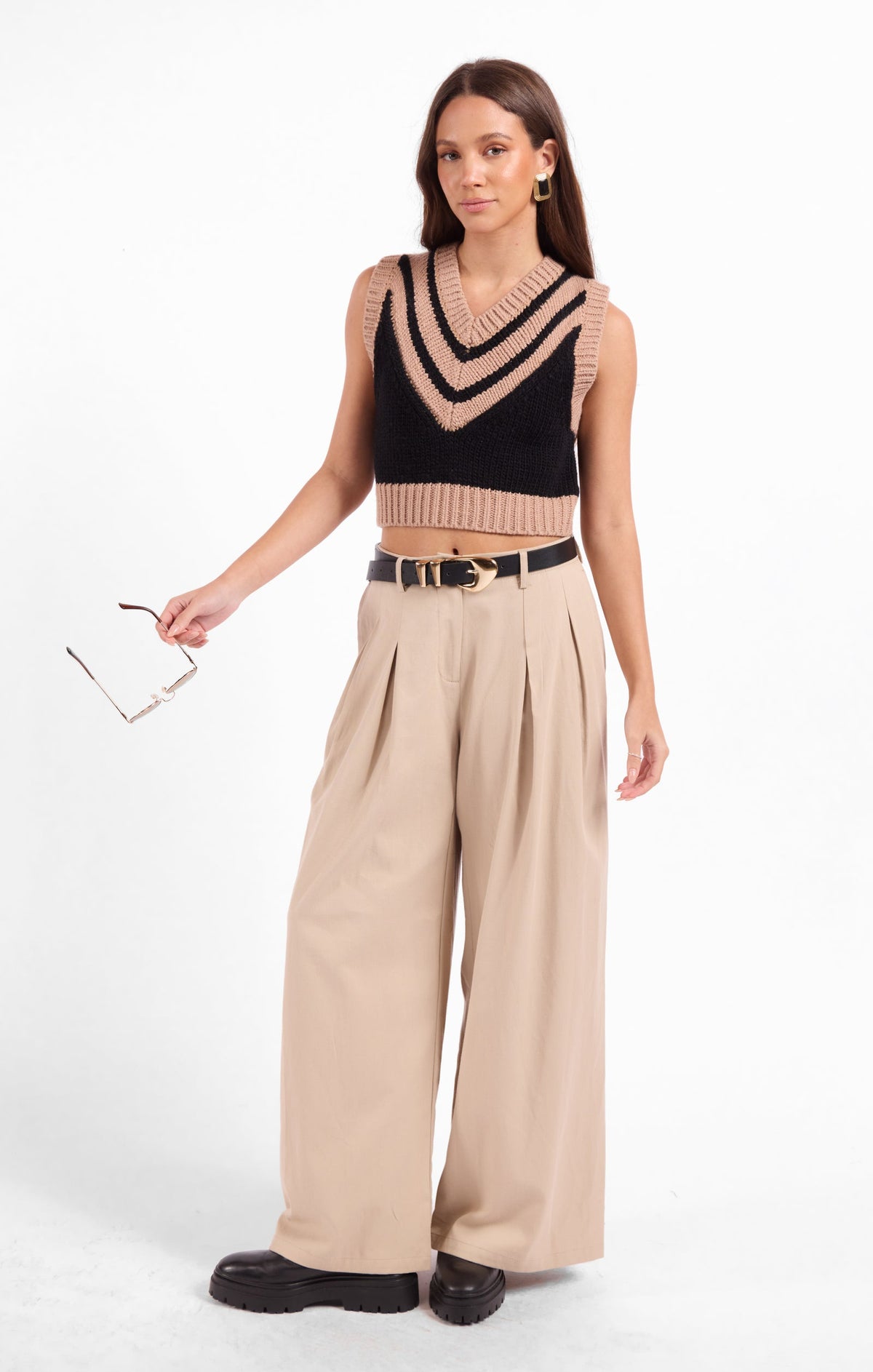Black sleeveless knit sweater vest with beige V-stitch stripes and ribbed neckline