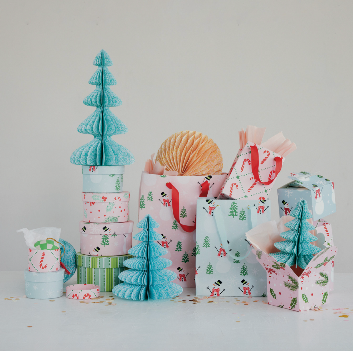 Festive gift bag set with multiple patterned paper bags in pink and blue with holiday motifs