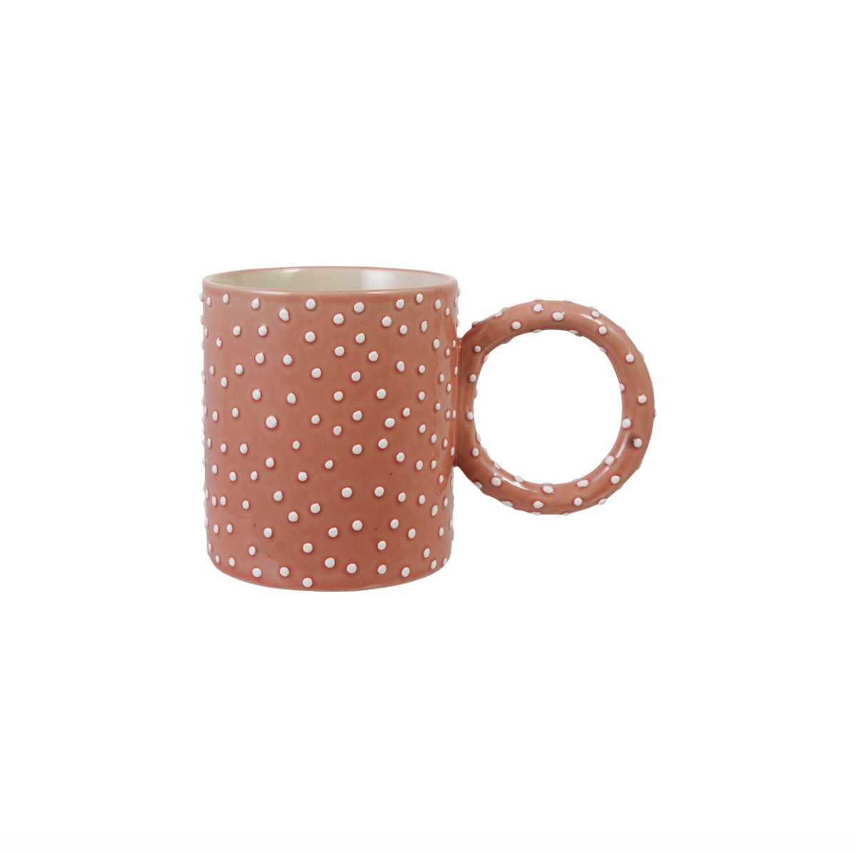Pink polka dotted ceramic mug with circular handle and white dot pattern