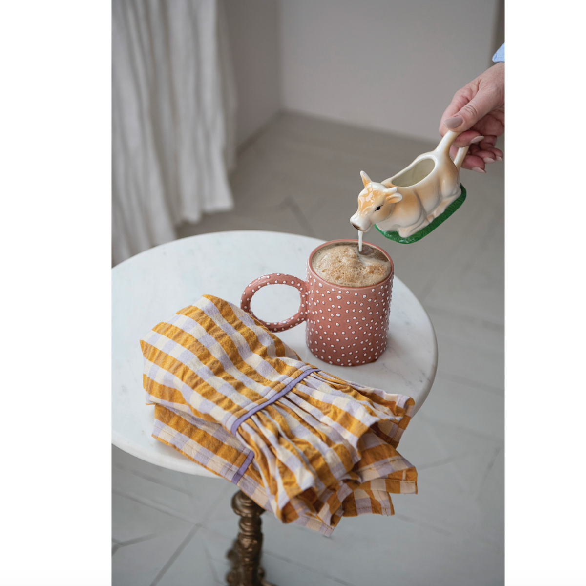 Pink polka dotted mug with loop handle on tabletop