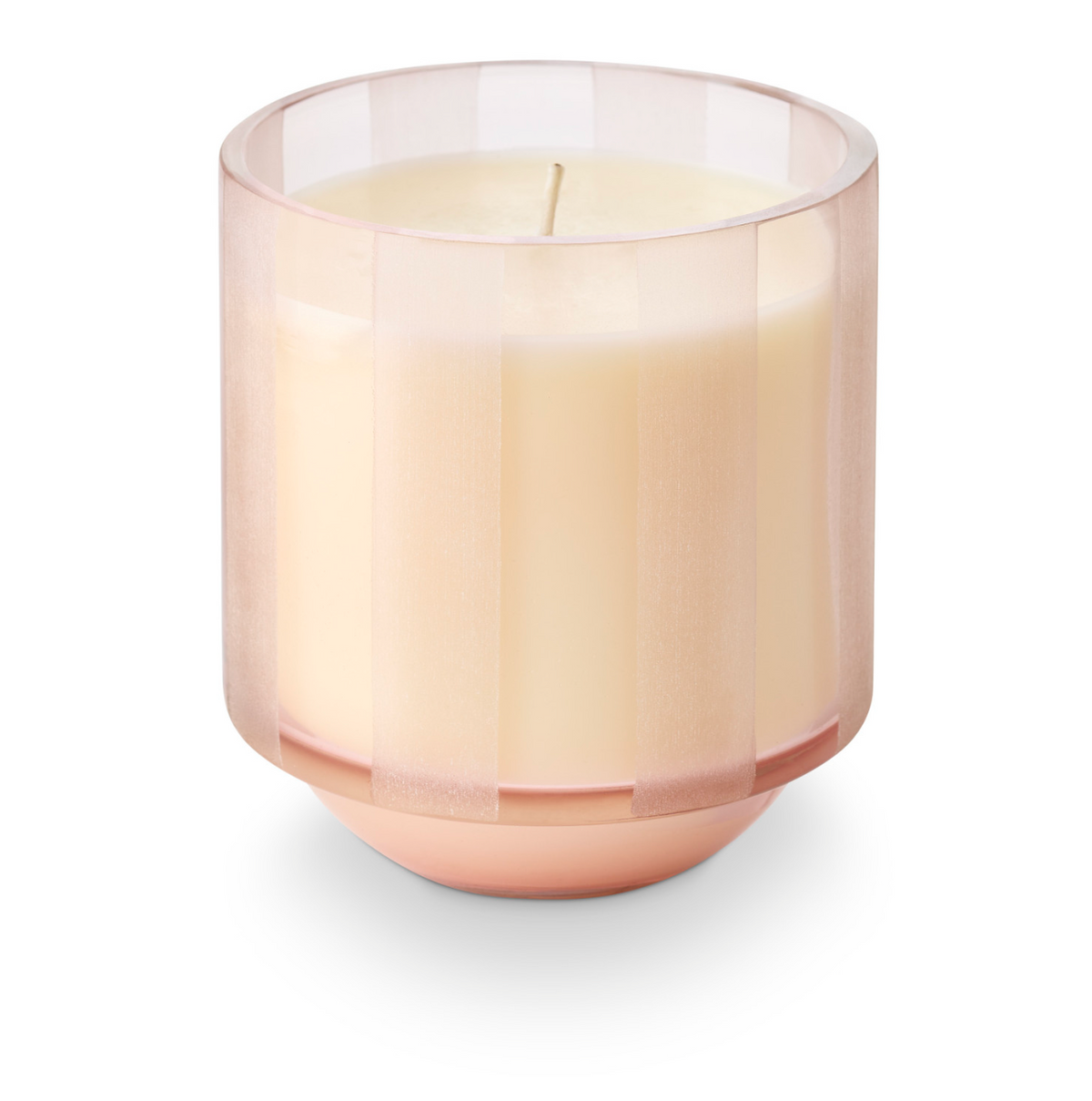 Pink striped etched glass candle holder with lit cream wax candle inside