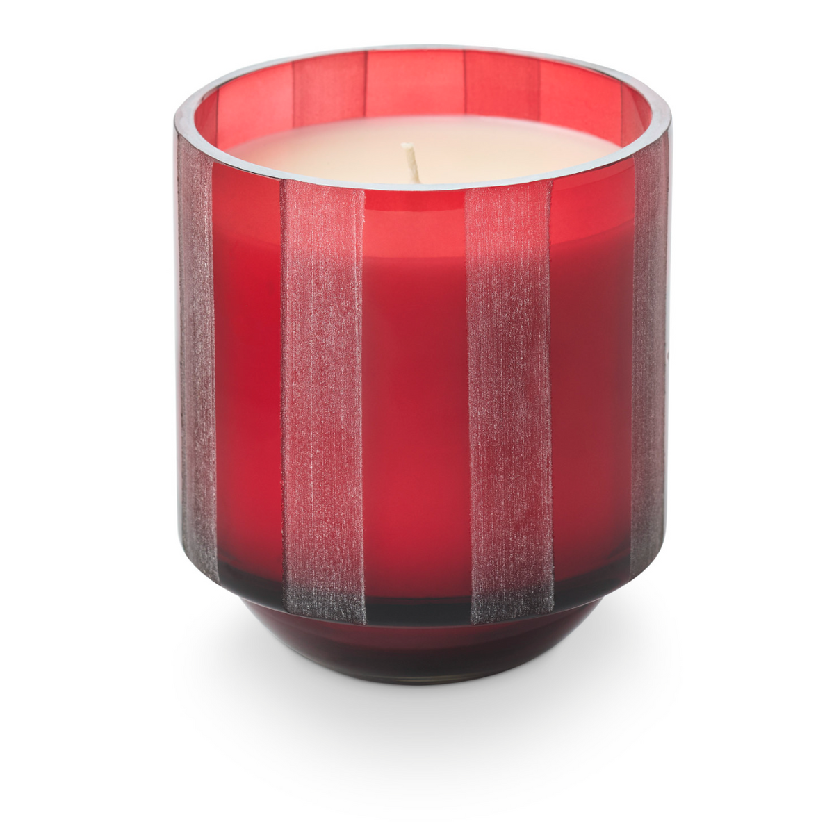 Red striped etched glass candle holder with lit wick and red wax candle