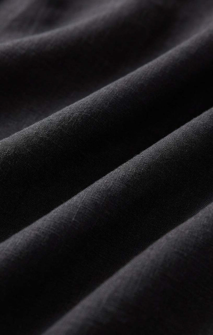 Black poplin fabric close-up, smooth matte weave texture