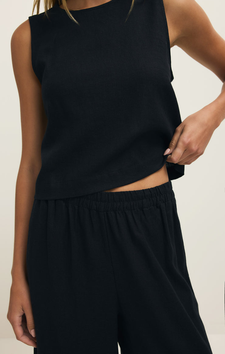 Sloane black linen sleeveless top close-up: curved hem and gathered waist seam