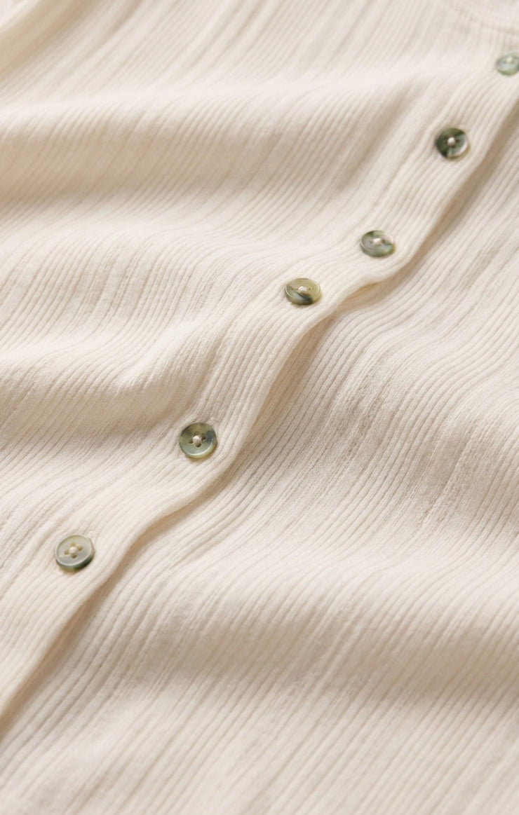 Cream pointelle knit tank fabric with small greenish buttons along front