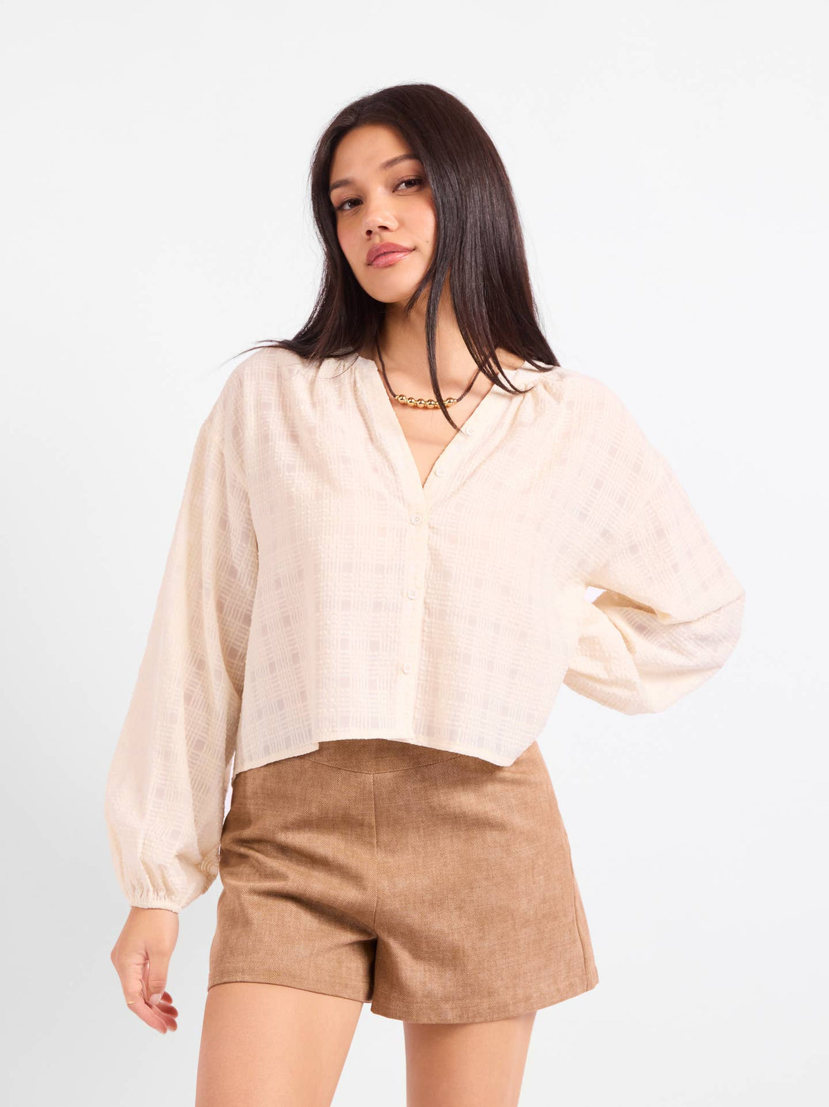 Light beige gauze blouse, V-neck with buttons and billowy sleeves, cropped length