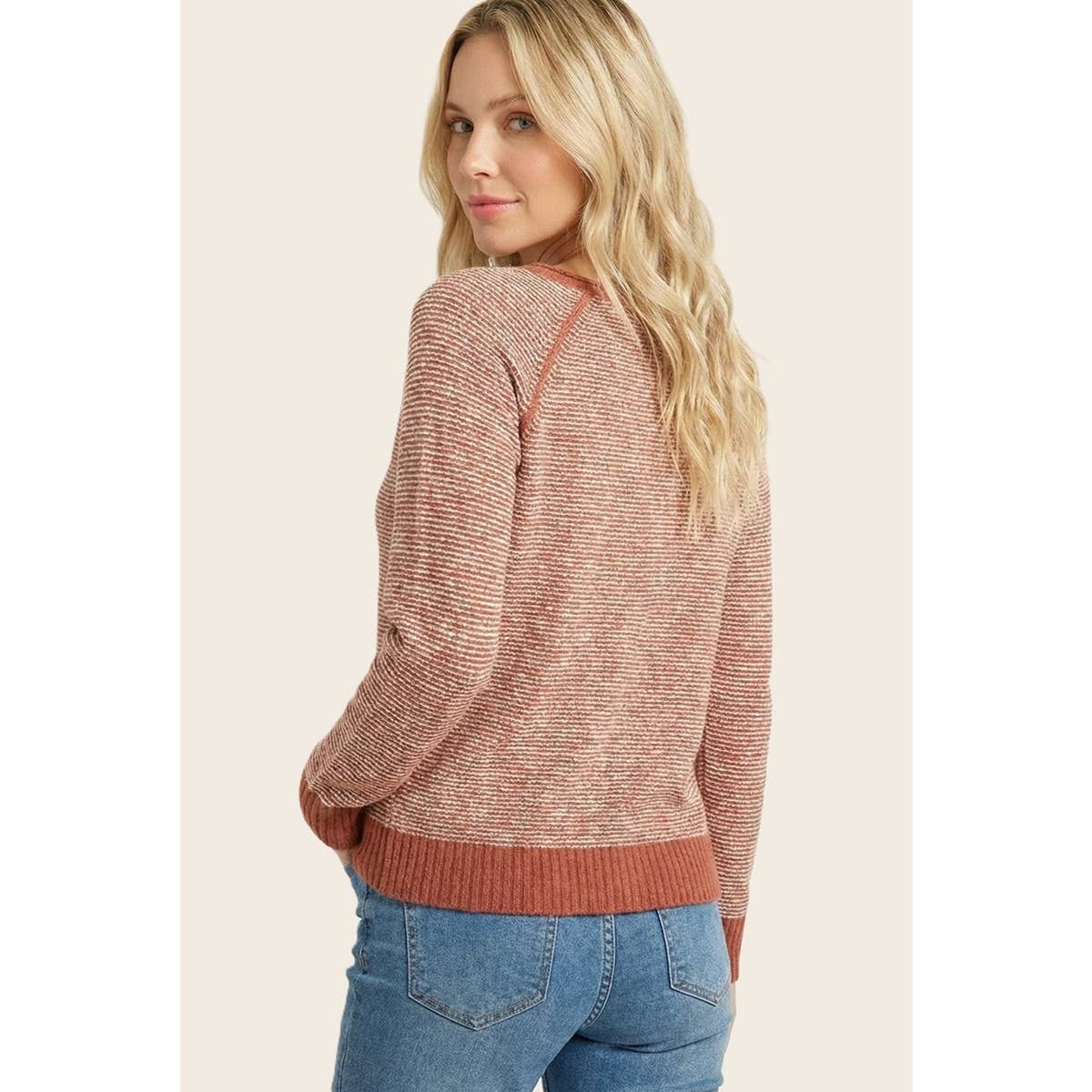 Rust pinstriped crewneck sweater with ribbed hem, shown from side