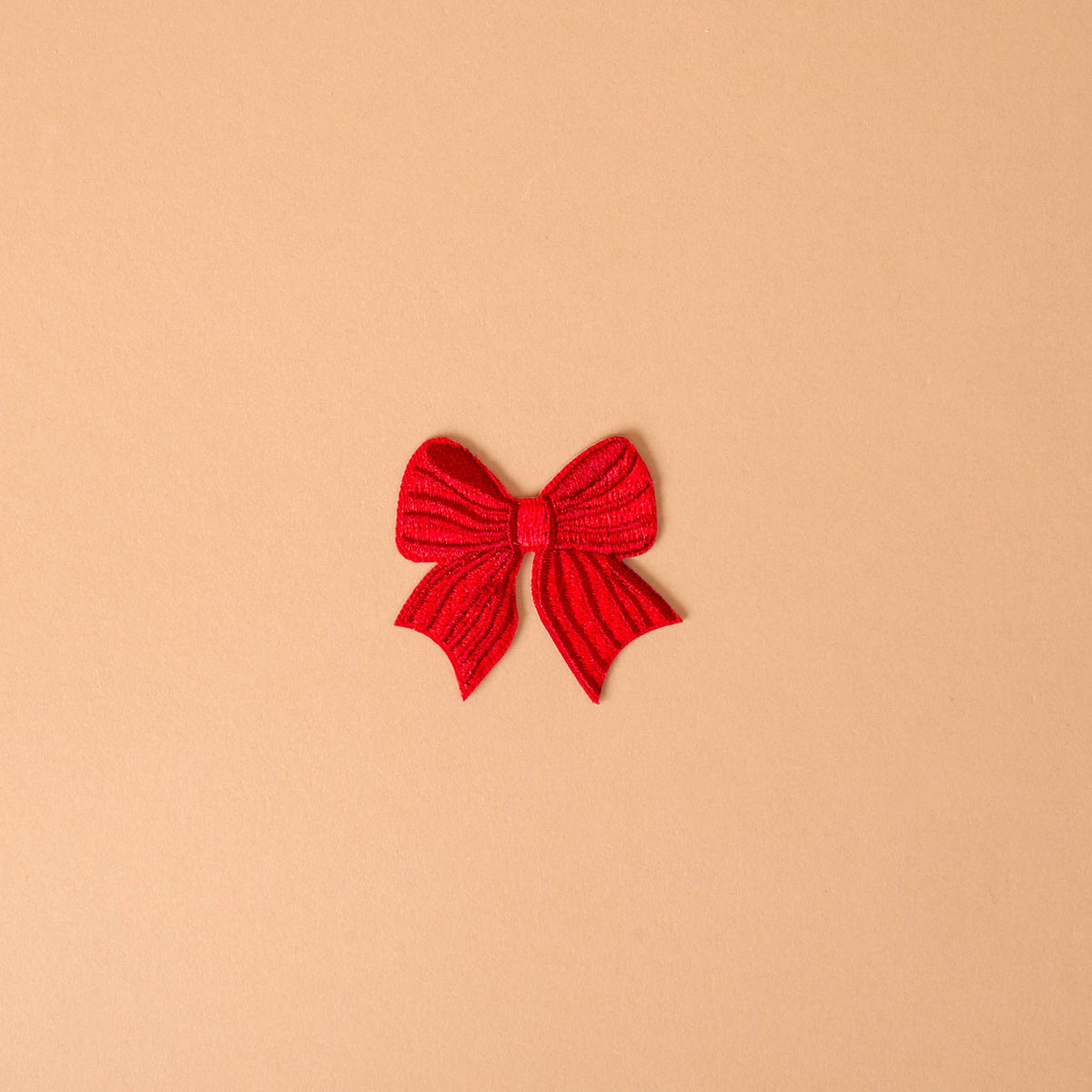 Red bow iron-on patch with textured fabric