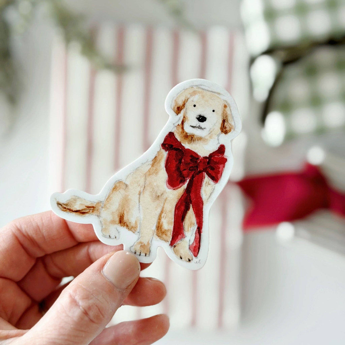Christmas dog sticker of a tan puppy wearing a red bow and scarf