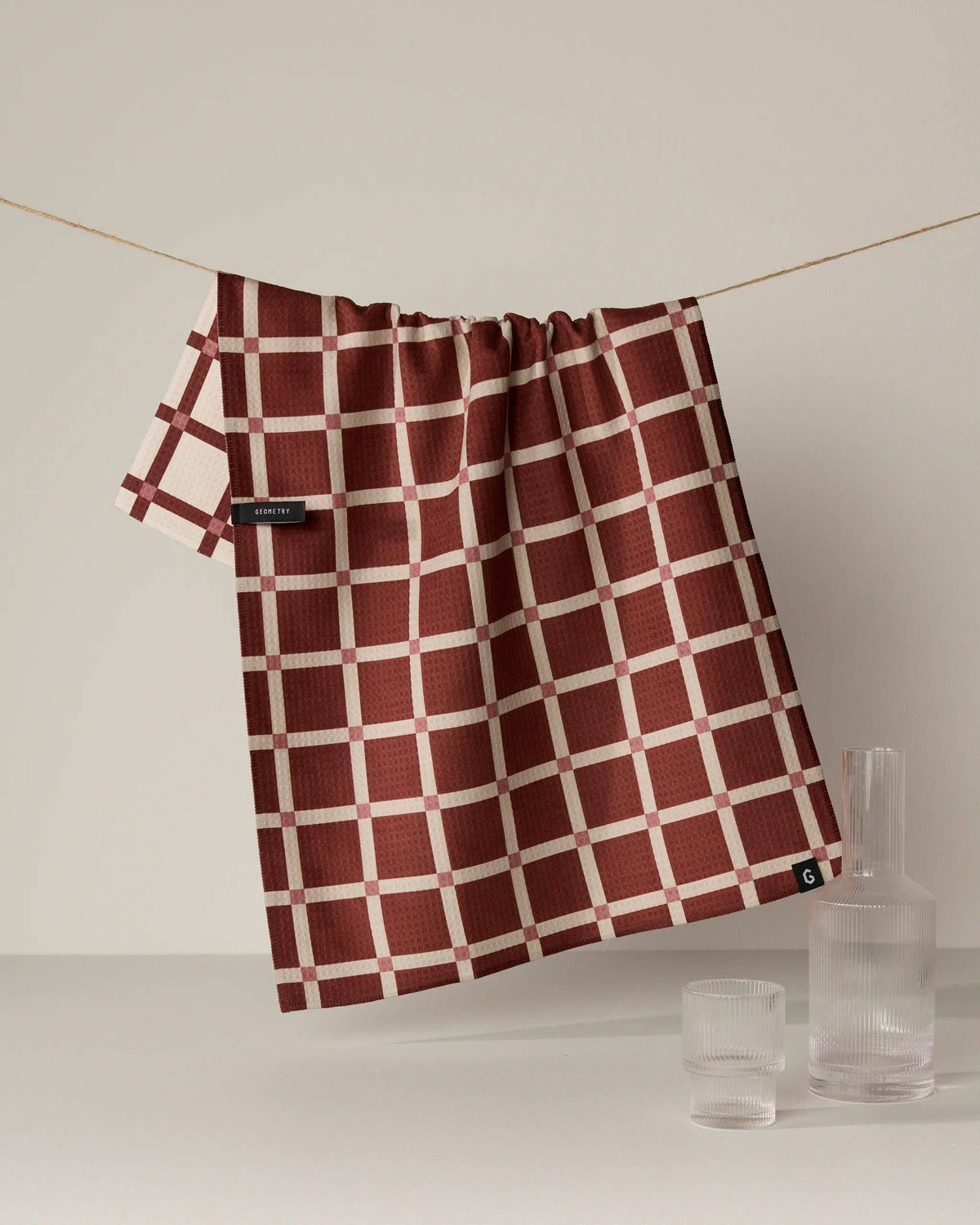 Red and white checkered kitchen towel with stitched label and gathered top