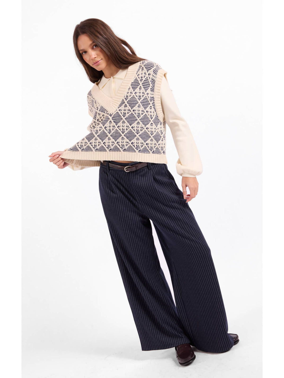 Cream sleeveless sweater vest with blue geometric lattice pattern and V-neck