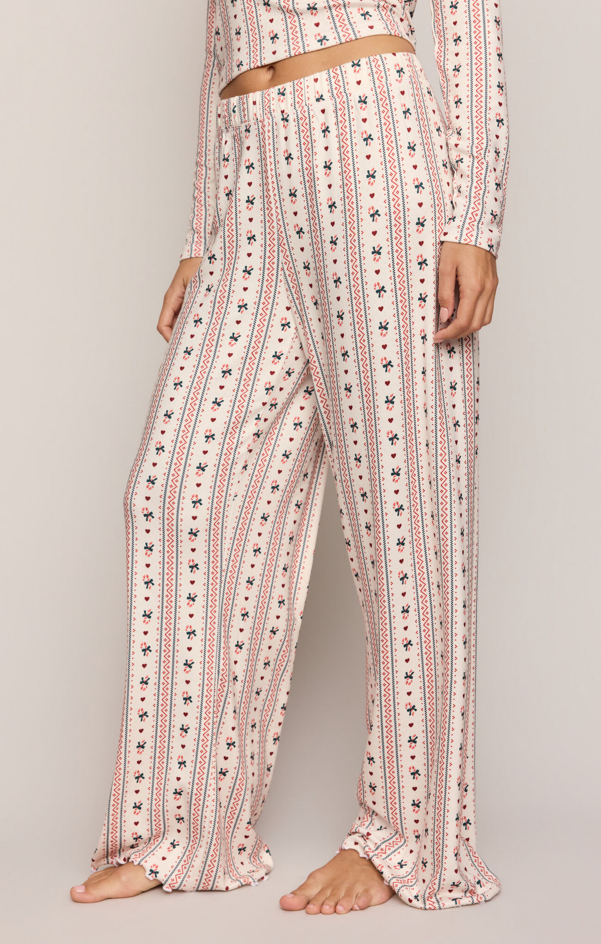 Candy cane print pajama pants, off-white with red stripes and blue motifs, elastic waist
