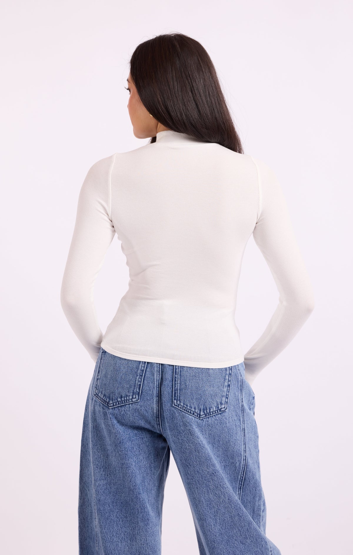 Back view of white knit turtleneck top with long sleeves
