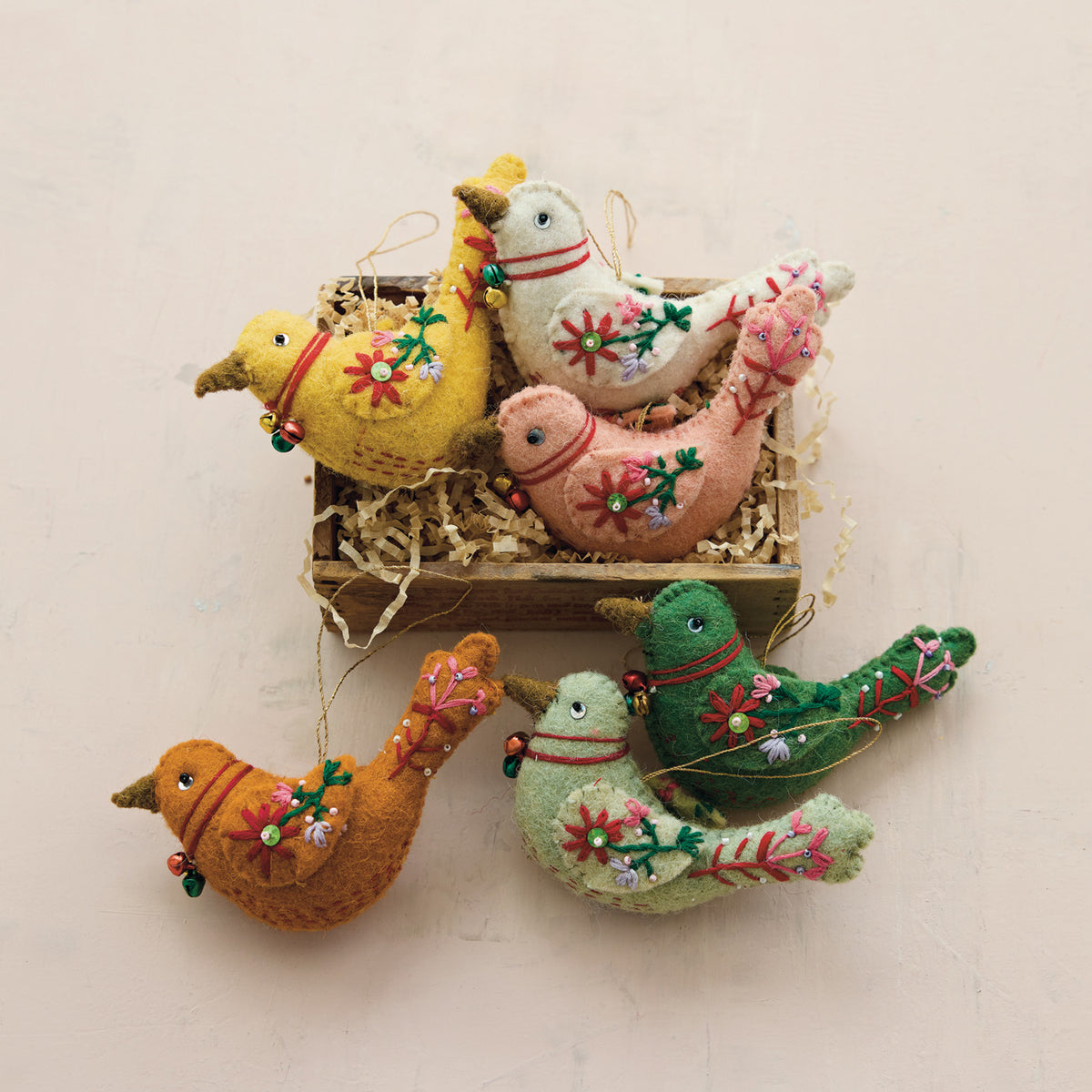 Assorted felt bird ornaments with flower appliques, arranged in a box